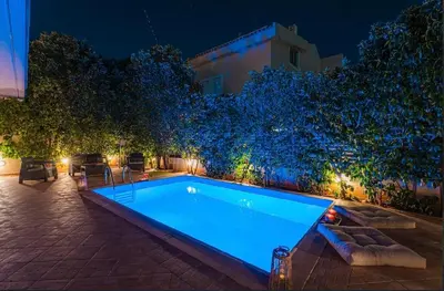 a swimming pool in a backyard at night at Βίλα Λαγονήσι in Kalívia Thorikoú