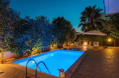 a swimming pool in a backyard at night at Βίλα Λαγονήσι in Kalívia Thorikoú