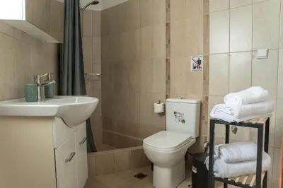 a bathroom with a toilet and a sink and a shower at Asclepius apartment Athens Airport in Spáta