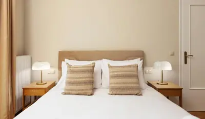 a bedroom with a white bed with two lamps at The Athenian Aroma - 3BDRM Exclusive Residence in Athens