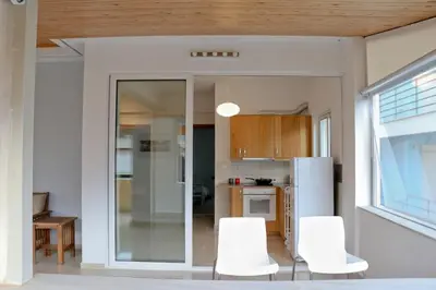 a kitchen with white chairs and a white refrigerator at Sea & garden view cozy apartment with good privacy in Athens