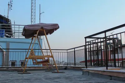 a chair with an umbrella on top of a building at Sea & garden view cozy apartment with good privacy in Athens