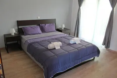 a bedroom with a large bed with two towels on it at Sea & garden view cozy apartment with good privacy in Athens
