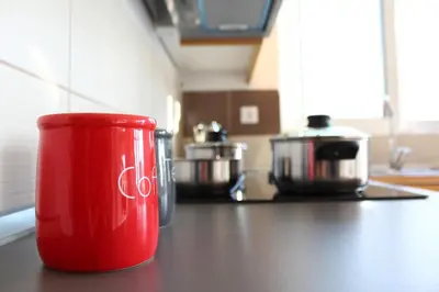 a red coffee cup sitting on a counter in a kitchen at Sea & garden view cozy apartment with good privacy in Athens
