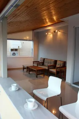 a living room with couches and a table and chairs at Sea & garden view cozy apartment with good privacy in Athens