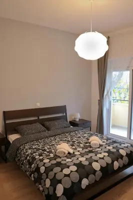 a bedroom with a bed with a black and white comforter at Sea & garden view cozy apartment with good privacy in Athens