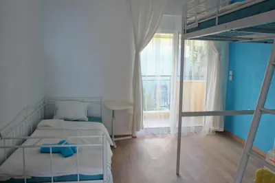 a bedroom with a bunk bed with a blue wall at Sea & garden view cozy apartment with good privacy in Athens