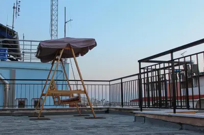 a chair with an umbrella on top of a building at Sea & garden view cozy apartment with good privacy in Athens
