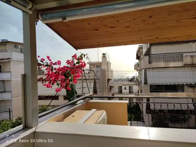 a balcony with a vase of flowers on a balcony at Sea & garden view cozy apartment with good privacy in Athens