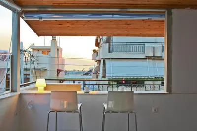 a balcony with two chairs and a table and a window at Sea & garden view cozy apartment with good privacy in Athens