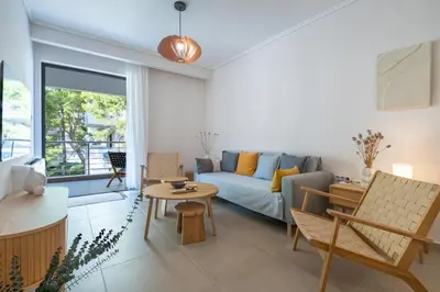 a living room with a couch and a table at Seaview Balcony in Varkiza by ΜΡS in Vari