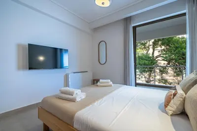 a bedroom with a large bed with a large window at Seaview Balcony in Varkiza by ΜΡS in Vari