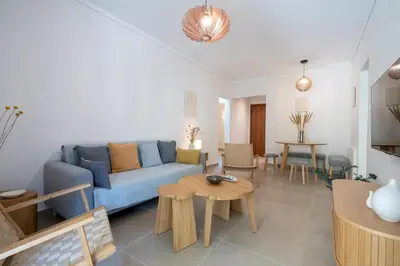 a living room with a blue couch and a table at Seaview Balcony in Varkiza by ΜΡS in Vari