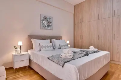 a bedroom with a large white bed with towels on it at City Chic Living-3BR Kallirrois in Athens