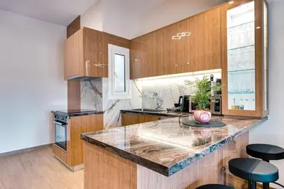 a kitchen with wooden cabinets and a counter top at City Chic Living-3BR Kallirrois in Athens