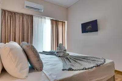 a bedroom with a bed with pillows and a window at City Chic Living-3BR Kallirrois in Athens