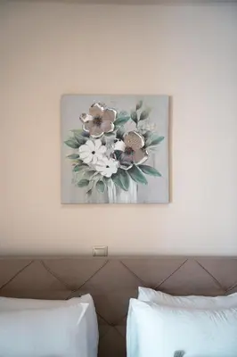 a painting of flowers on the wall above a bed at City Chic Living-3BR Kallirrois in Athens