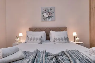 a bedroom with a large white bed with two lamps at City Chic Living-3BR Kallirrois in Athens