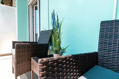 two wicker chairs and a potted plant on a balcony at City Chic Living-3BR Kallirrois in Athens