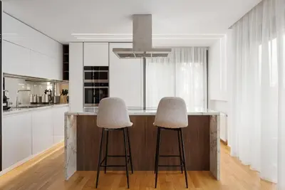 a kitchen with two stools at a counter at Glyfada Golden Stay in Athens