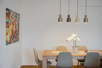 a dining room table with chairs and a painting at Glyfada Golden Stay in Athens