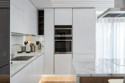 a white kitchen with a sink and a stove at Glyfada Golden Stay in Athens