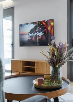 a living room with a table with a vase of flowers at Glyfada Golden Stay in Athens