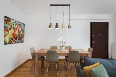 a dining room with a wooden table and chairs at Glyfada Golden Stay in Athens