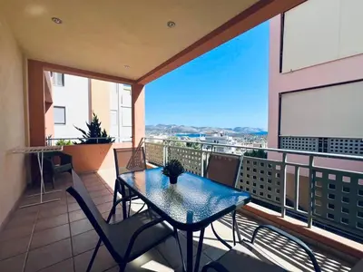 a patio with a table and chairs on a balcony at Anavyssos Azure in Anavissos