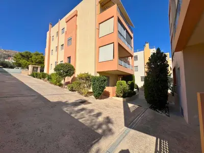 a tall building with trees in front of it at Anavyssos Azure in Anavissos