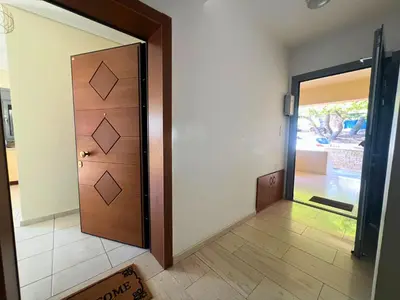 a wooden door in a room with a tile floor at Anavyssos Azure in Anavissos