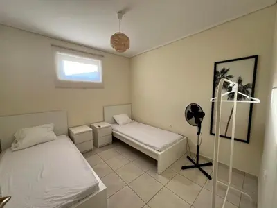 a bedroom with two beds and a window at Anavyssos Azure in Anavissos