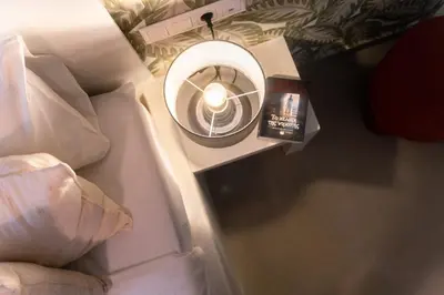 a small table with a light and a book on it at Casa Aura-Artistic Living Faliro in Athens