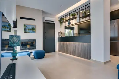 a living room with a table and blue chairs at Casa Aura-Artistic Living Faliro in Athens
