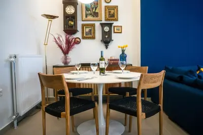 a table with four chairs and wine glasses on it at Casa Aura-Artistic Living Faliro in Athens