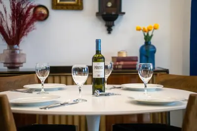 a bottle of wine sitting on a table with glasses at Casa Aura-Artistic Living Faliro in Athens