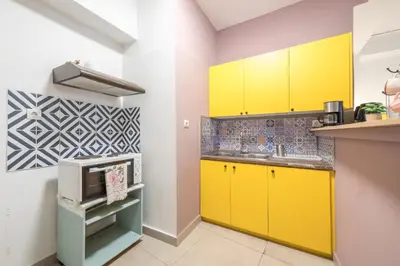 a kitchen with yellow cabinets and a sink at Ground floor apartment, 100m from metro Panormou in Athens