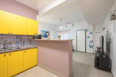 a kitchen with yellow cabinets and a refrigerator at Ground floor apartment, 100m from metro Panormou in Athens