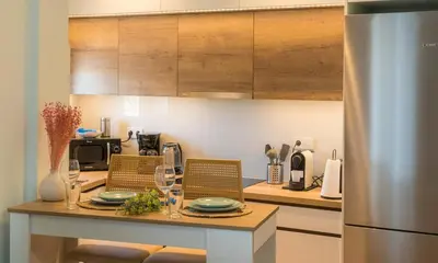 a kitchen with a table with wine glasses on it at Highway Haven - Halandri in Athens