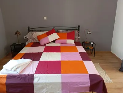 a bed with a colorful blanket and pillows on it at Lemon tree's House in Athens in Athens