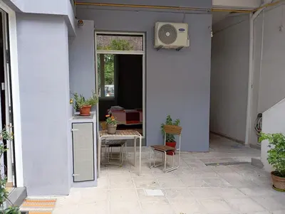 a patio with a table and a window with a speaker at Lemon tree's House in Athens in Athens