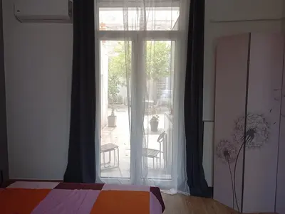 a bedroom with a large window with a view of a patio at Lemon tree's House in Athens in Athens
