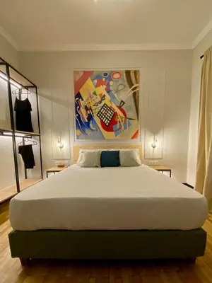 a bedroom with a large bed with a painting on the wall at Elegant apartment in Kypseli in Athens