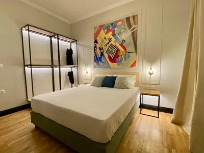 a bedroom with a bed and a painting on the wall at Elegant apartment in Kypseli in Athens