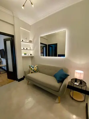 a living room with a couch and a mirror at Elegant apartment in Kypseli in Athens