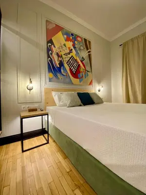 a bedroom with a bed with a painting on the wall at Elegant apartment in Kypseli in Athens