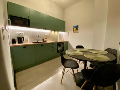 a kitchen with green cabinets and a table and chairs at Elegant apartment in Kypseli in Athens
