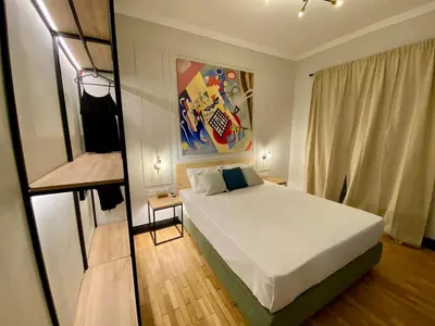 a bedroom with a bed and a painting on the wall at Elegant apartment in Kypseli in Athens