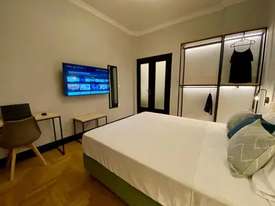 a bedroom with a large white bed and a desk at Elegant apartment in Kypseli in Athens