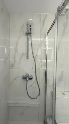 a shower with a shower head in a bathroom at Andria's Apartment in Athens